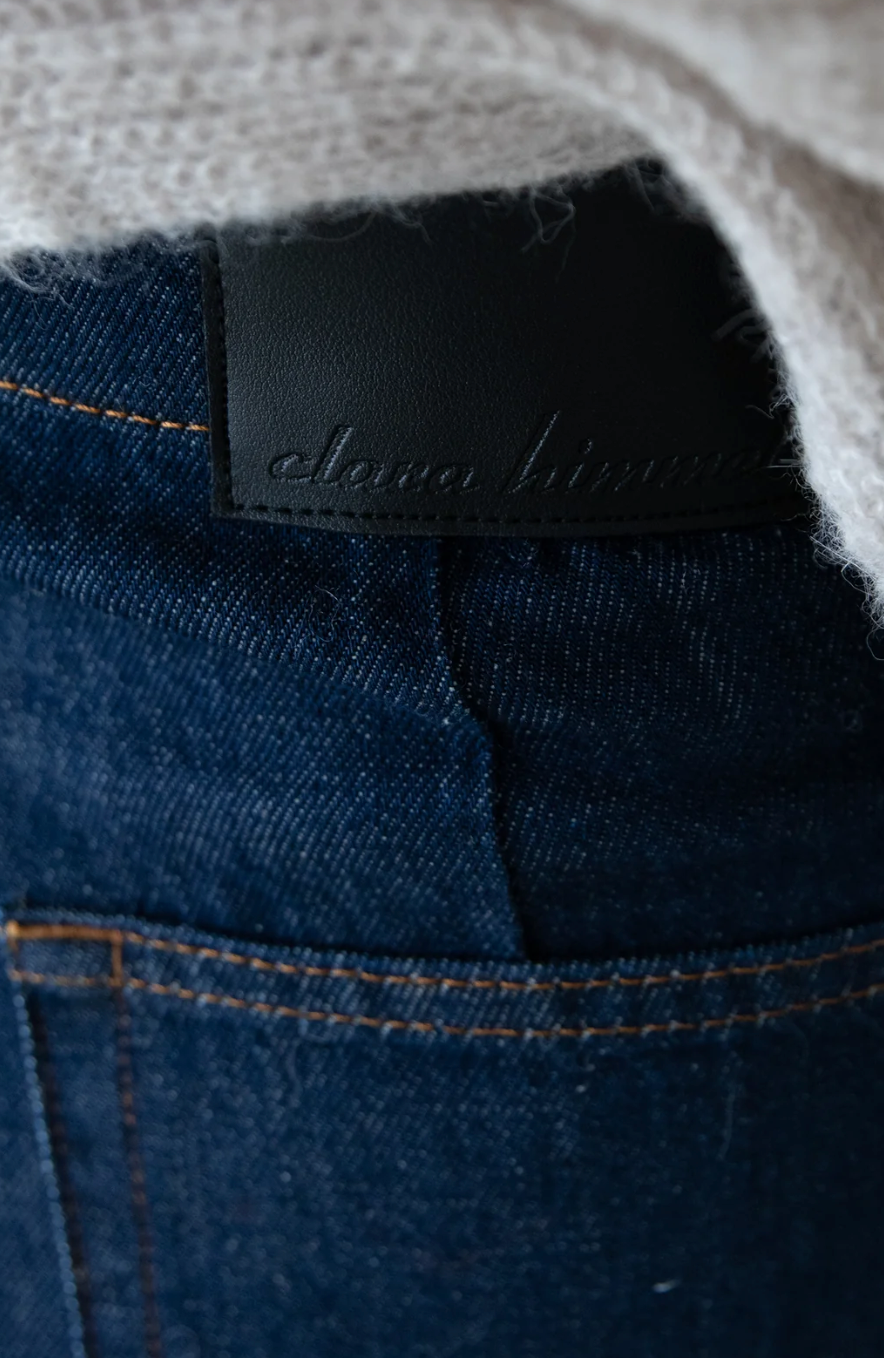 Detail des dunklen Clara-Himmel-Logo-Patches am Bund der Barrel Jeans Dark Blue